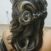 Penteado cacheado com trança lateral.