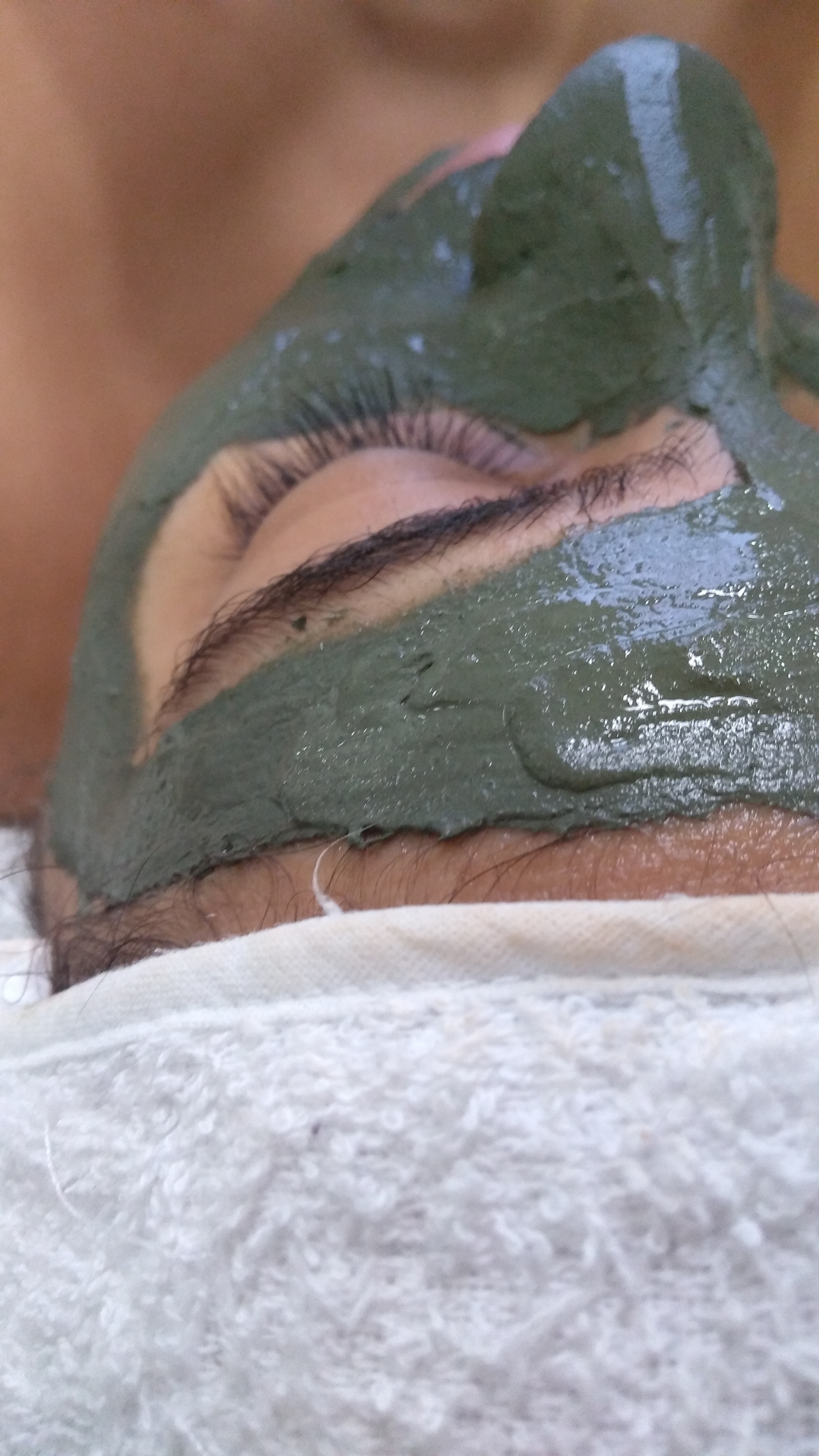 Aplicação da máscara de argila verde da marca Bel Col em aula prática de cosmetologia. estética estudante (esteticista)