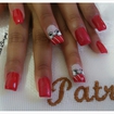Unhas decoradas com laço e aplicação de pedararia.