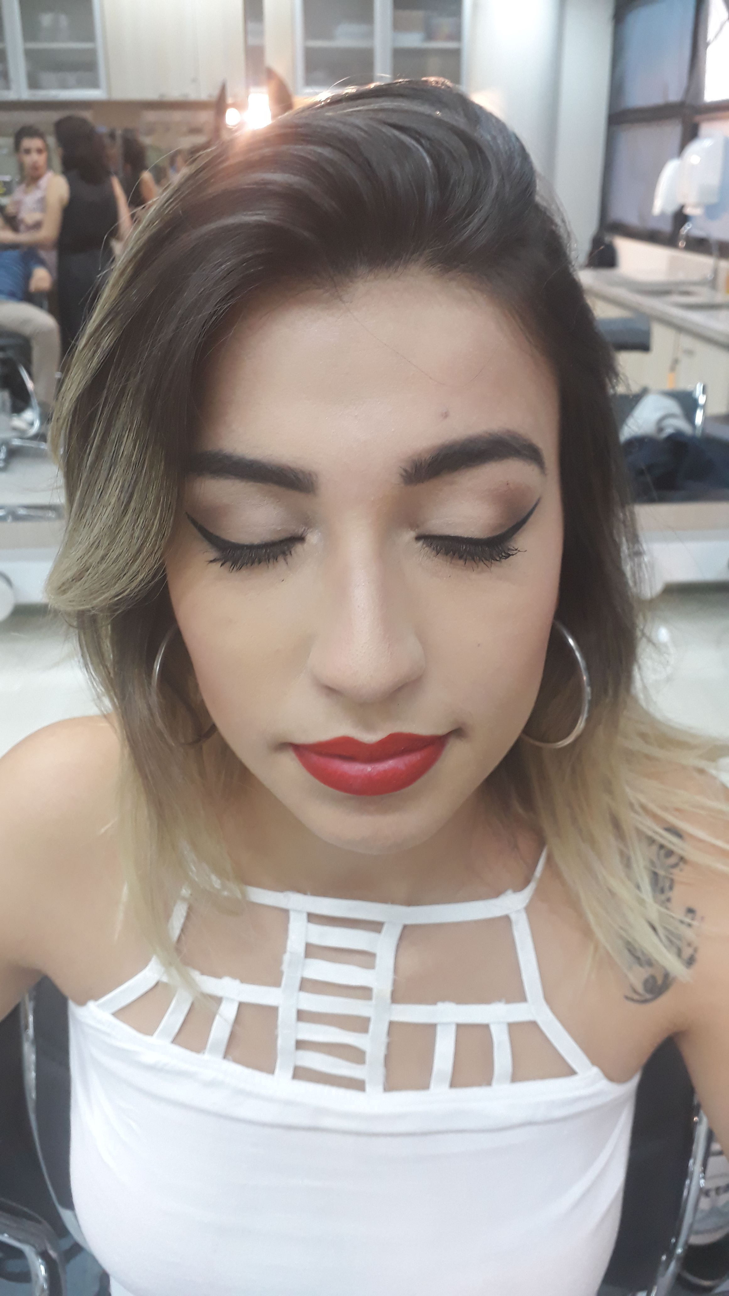 Um lindo desenho de pálpebra esfumado com delineado gatinho e ombré lip vermelho. maquiagem maquiador(a)