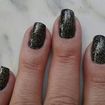 Esmaltação com esmalte na cor preto finalizado com esmalte gliter dourado.