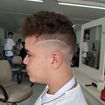 Low fade, com corte curly despojado.